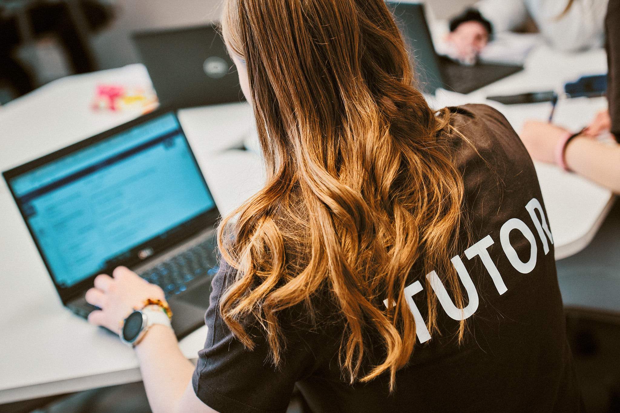 Opiskelija, jonka paidan selässä lukee Tutor.